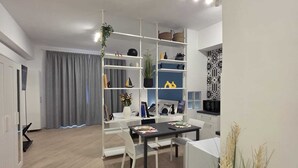 A modern living space with a dining area, white furniture, and a decorative plant. - Townhouse 41 - Trieste - by Be Your Home (Civitavecchia)