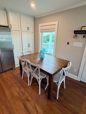 A kitchen with white cabinets, a wooden dining table, and chairs. - Coming Soon: Check out this gem at The Point.  4BR, 3BA, 3-minute walk to beach. (Emerald Isle)