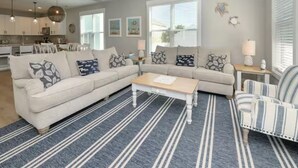 Un salon avec un canapé, une table basse, un tapis à rayures et un fauteuil à rayures.