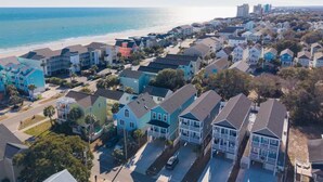 Une zone résidentielle côtière avec des maisons, une plage et un ciel dégagé.