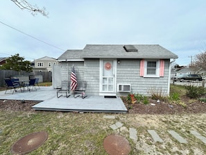 A house with a deck, a flag, and a garage.