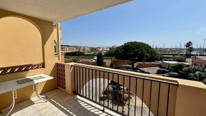 Un balcone con vista su un porto turistico e edifici.