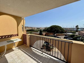 Ein Balkon mit Blick auf einen Hafen und Gebäude.