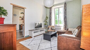 A living room with a TV, sofa, coffee table, and a potted plant. - 1 bedroom beautiful home in Verzeille (Verzeille)