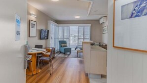 Een modern interieur met een eethoek, een blauwe fauteuil en een groot raam.