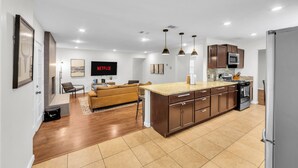 Una cocina moderna con una isla central, microondas integrado y electrodomésticos de acero inoxidable.