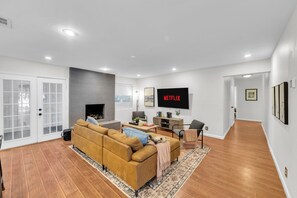 Un salon moderne avec un canapé, un téléviseur et une cheminée.