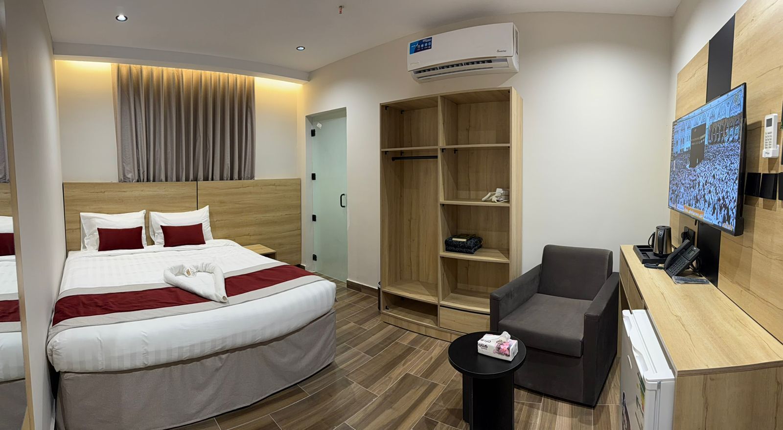 Une chambre d’hôtel comprenant un lit, un bureau, une chaise, une armoire et un téléviseur.