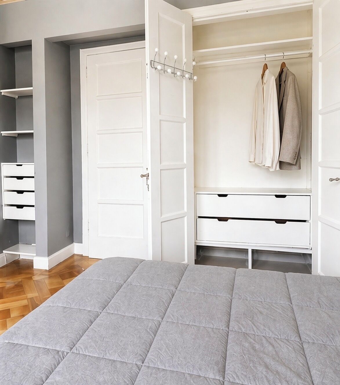 Ein Schlafzimmer mit Bett, Kleiderschrank und einer Tür.