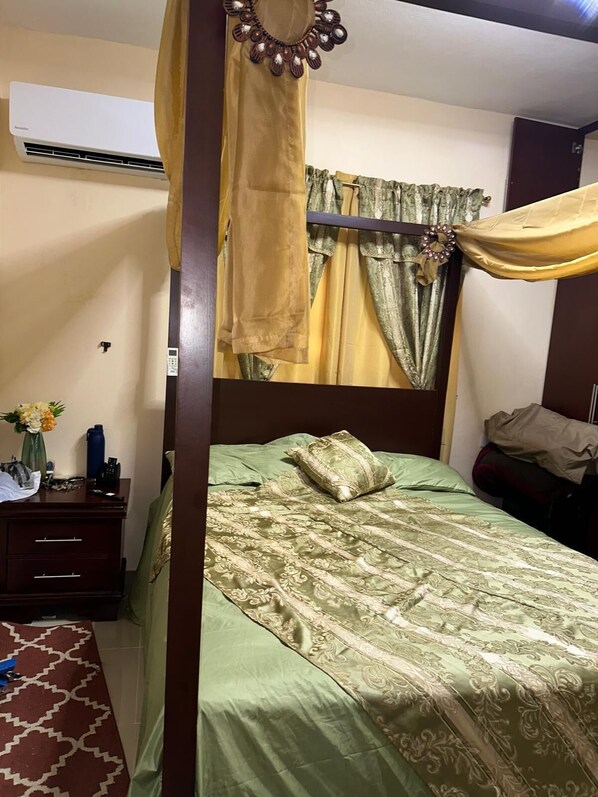 A bedroom with a bed, a nightstand, a mirror, and a wall-mounted air conditioner. - 3-bedroom house in perfect Sánchez with cool AC and comfort (Sánchez)