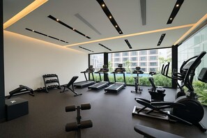 Ein modernes Fitnessstudio mit Laufbändern, Kurzhanteln und Trainingsgeräten.