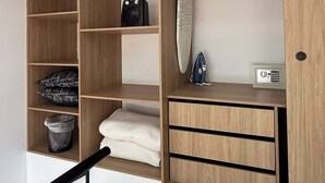 A modern storage unit with multiple compartments, including shelves, drawers, and a hanging area. - NOK Beautiful Apartment in Chico (Bogotá)