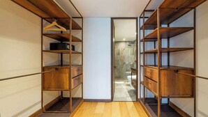 A walk-in closet with wooden shelving and a wooden floor. - NOK Amazing Studio in Candelaria (Bogotá)
