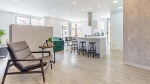 A modern interior with a sofa, bar stools, and a kitchen area. - NOK Modern 3BR in Usaquén (Bogotá)