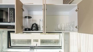 A kitchen with a microwave, blender, and wine glasses on the counter. - NOK Amazing Duplex in Parque 93 (Bogotá)
