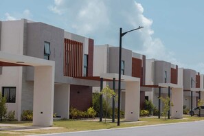 A modern building with a flat roof, large windows, and a clean, minimalist design. - NOK Modern 1BR Apartment With Terrace in Vistacana (Punta Cana)