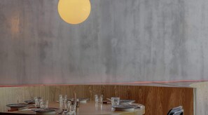 A restaurant with a wooden booth seating area, a grey wall with a circular light fixture, and a red neon light along the ceiling. - NOK Perfect 1 BR in Chapinero (Bogotá)