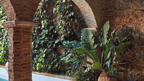 A pool area with tiled flooring, brick arches, and potted plants. - NOK Luxury Colonial Villa 6BR With Pool, Staff & Breakfast at Getsemani (Cartagena)