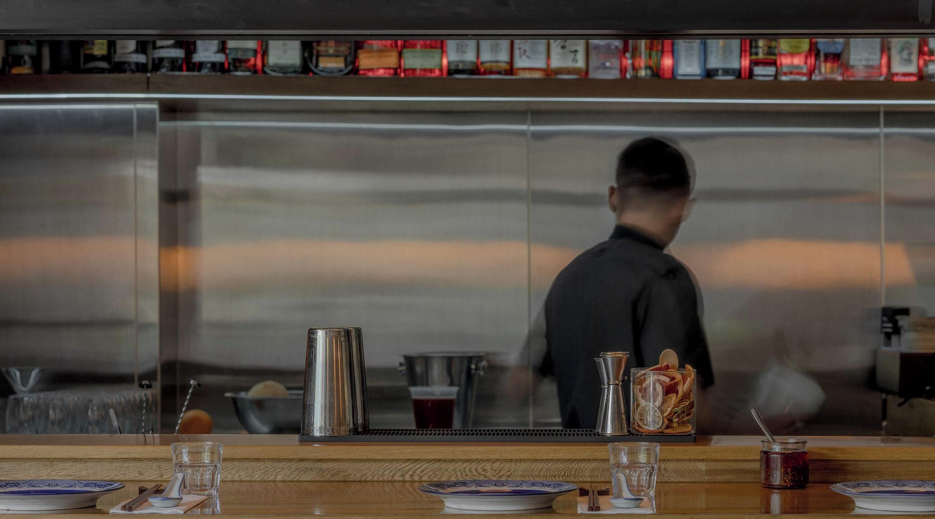 A bar area with a counter, a kettle, and a glass.