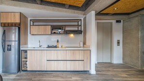 A modern kitchen with wooden cabinets, a stainless steel refrigerator, and a built-in oven. - NOK Centric 1 BR in Chapinero (Bogotá)