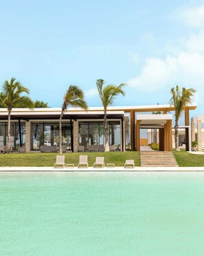 Um resort moderno com piscina, espreguiçadeiras e palmeiras.