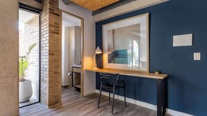 A room with a wooden ceiling, a desk with a chair, a large mirror, and a potted plant. - NOK Stunning 1 BR in Chapinero (Bogotá)