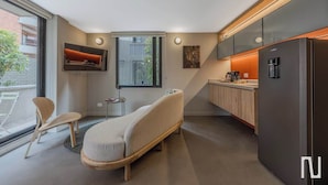 Eine moderne Küche mit einem integrierten Kühlschrank, einem Essbereich mit einem Stuhl und einem Fenster mit Ausblick.