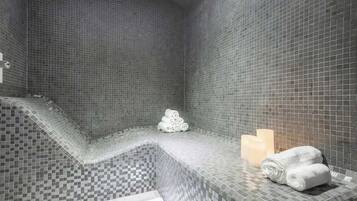 Un baño moderno con un estampado de baldosas a cuadros, un banco integrado y toallas cuidadosamente dobladas.