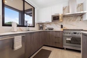 A modern kitchen with a built-in oven, microwave, and coffee maker. - NOK Villa Senzoria Spacious 3BR Villa With Patio By Vistacana (Punta Cana)