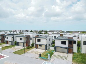 A residential area with modern, multi-story buildings, flat roofs, and a clear sky. - NOK Villa Senzoria Spacious 3BR Villa With Patio By Vistacana (Punta Cana)