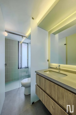 A modern bathroom with a large mirror, a wooden vanity, and a toilet. - NOK 1BR Loft With Private Stylish Balcony (Bogotá)