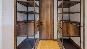 Um closet amplo com várias prateleiras e gavetas de madeira.