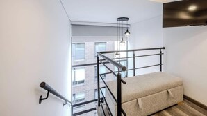 A modern room with a bunk bed, a hanging light fixture, and a TV mounted on the wall. - NOK Luxury Loft in Chico Norte (Bogotá)