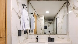 A modern bathroom with a large mirror, a sink, and a toilet. - NOK Luxury Loft in Chico Norte (Bogotá)