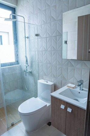A modern bathroom with a shower, toilet, and sink. - NOK Classy 3BR Villa by Vistacana Rentals (Punta Cana)