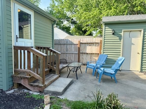 Eine Terrasse mit Holzdeck, einem Tisch und zwei Stühlen.