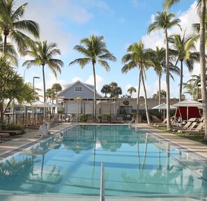 Ein Swimmingpool mit Liegestühlen und Palmen.