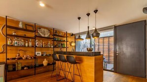 Een moderne keuken met houten planken, een bar en een grote schuifdeur.