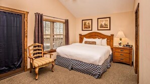 A bedroom with a bed, a chair, a nightstand, a lamp, a ceiling fan, and a window with curtains. - Cozy 2-bedroom condo in charming Pigeon Forge with AC and gym (Pigeon Forge)