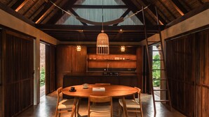 Una cocina moderna con una mesa redonda de madera, lámparas colgantes y armarios de madera.