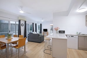 Eine moderne Wohnung mit Essbereich, Küche und Wohnzimmer.