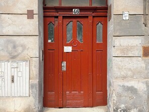 A red door with the number 46, a small window, and a doorbell. - Nowowiejska Green Point Apartment (Wrocław)