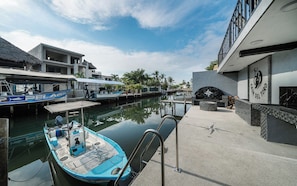 A marina with boats docked, a building with a stone facade, and a clear sky.