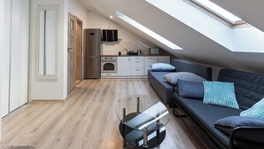 A modern loft apartment with a kitchen, dining area, and sleeping space. - Sikorskiego Comfort Studio #4 (Rzeszów)