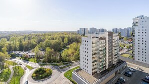 A modern apartment building with multiple floors, a parking area, and a surrounding green landscape. - Park Śląski Charming Studio (Katowice)