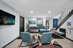 A modern living room with a sectional sofa, two armchairs, a coffee table, and artwork on the walls. - Bright Designer Villa near Fort Lauderdale / Beach (Wilton Manors)