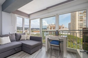 Ein Balkon mit Schreibtisch, einer Couch und einem Sessel.
