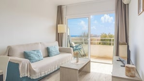 Un salon moderne avec un canapé, une table basse et un balcon offrant une vue agréable.