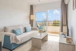 Ein modernes Wohnzimmer mit einer Couch, einem Couchtisch und einem Balkon mit Blick.