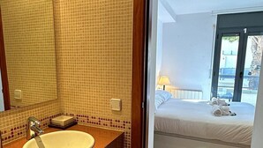 A bathroom with a sink, mirror, and tiled walls. - Sol, terraza y piscina en S’Agaró (Sagaro)